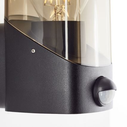 Brilliant - Āra sienas lampa ar sensoru MINOU 1xE27/10W/230V IP44 melna/dūmakains